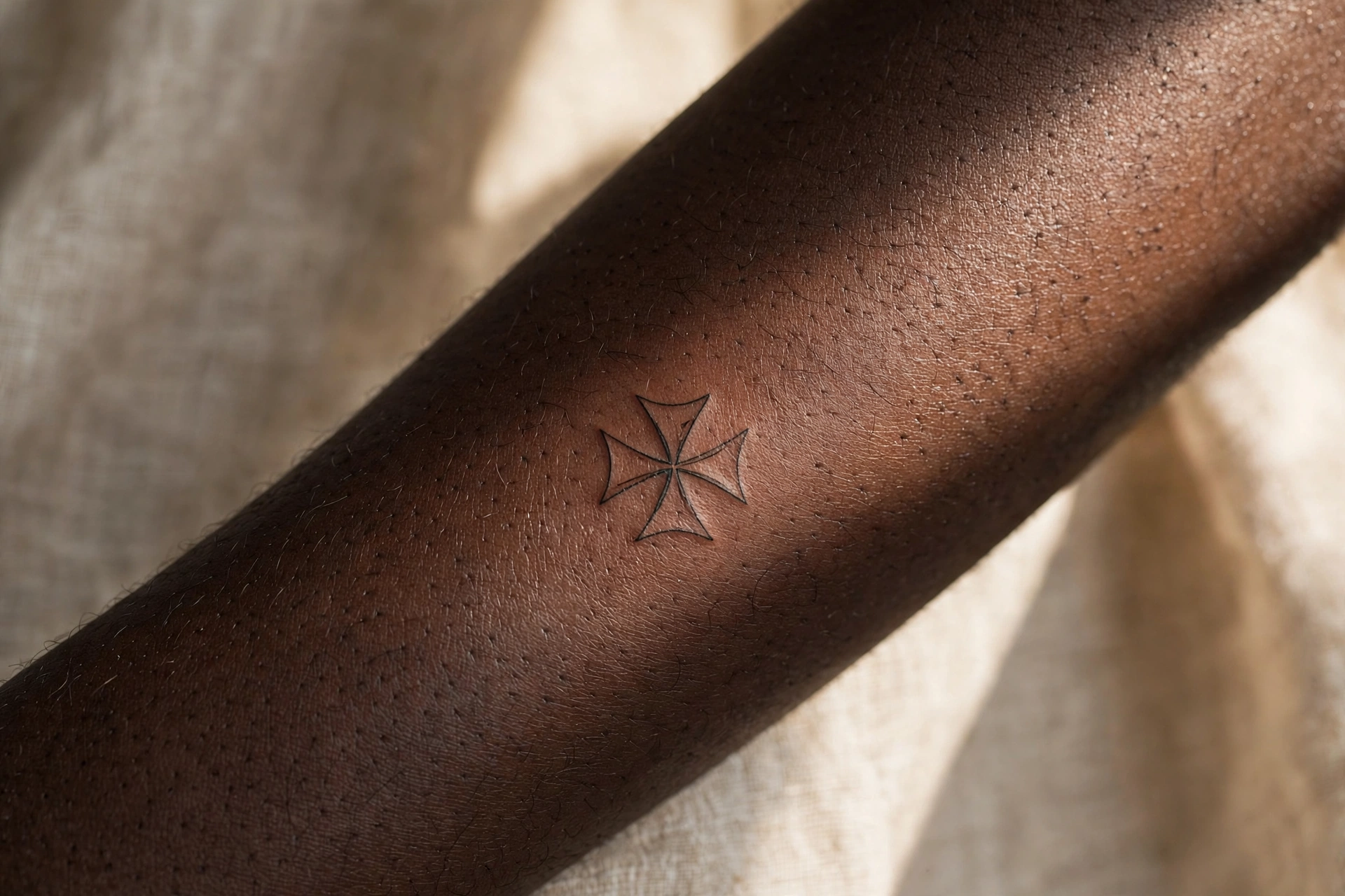 Maltese cross tattoo with eight points on a shoulder