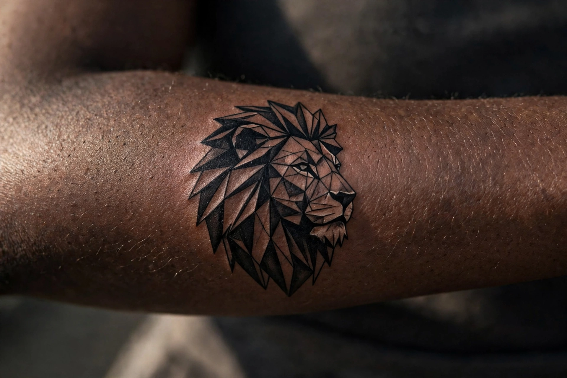 Low poly lion tattoo on man's shoulder