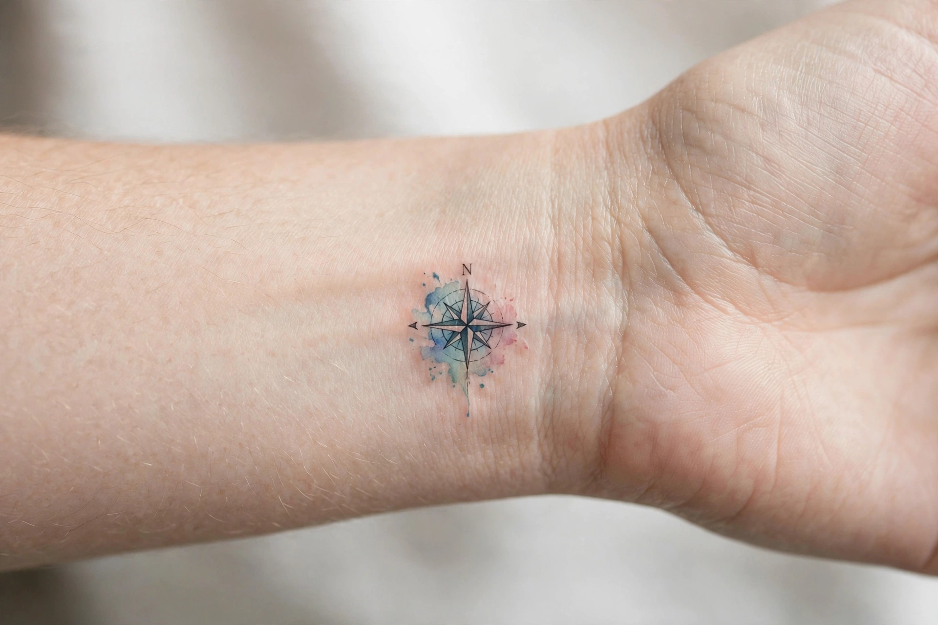 Tiny compass rose tattoo on the inner wrist