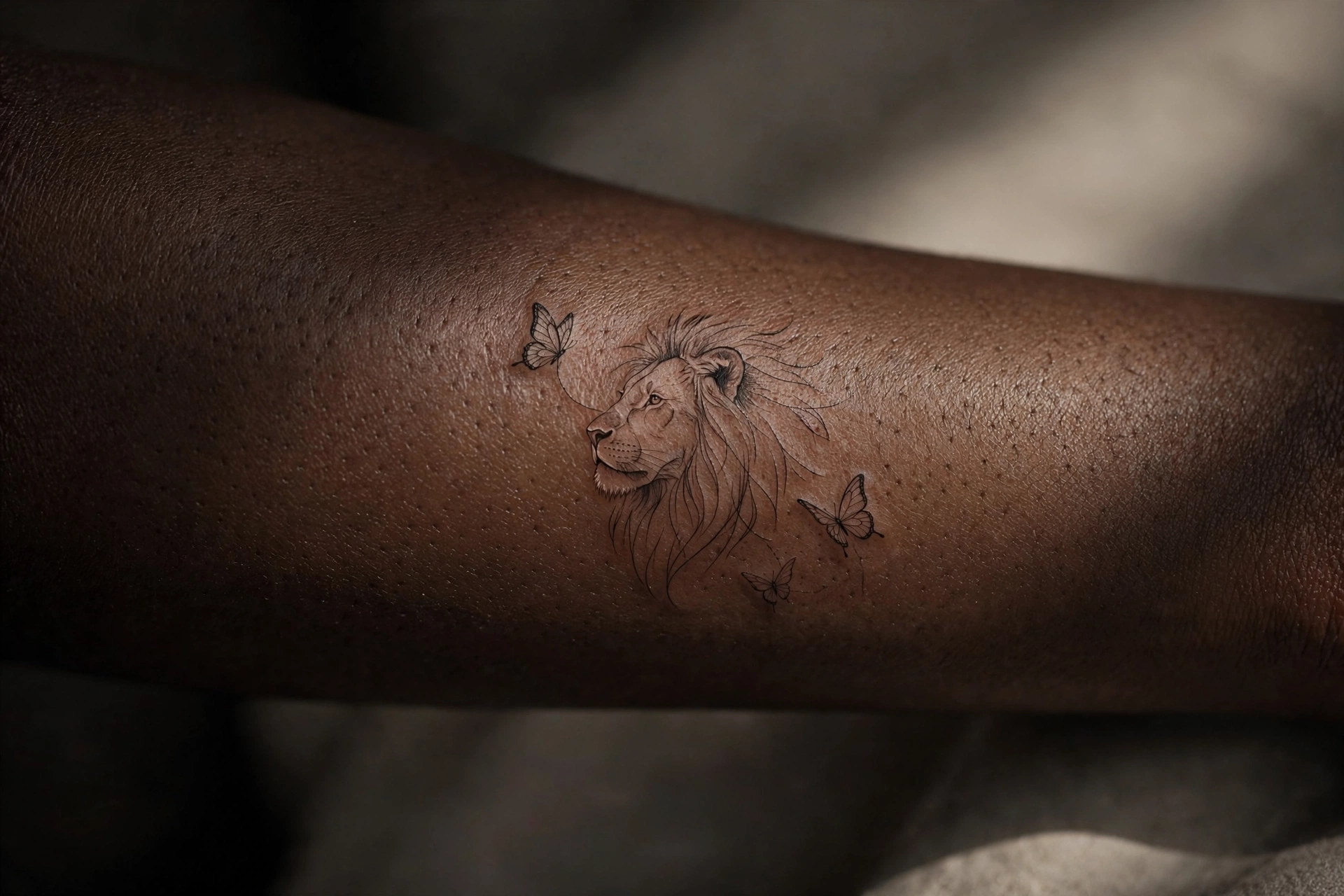 Lion with butterflies tattoo symbolizing transformation on a man's shoulder