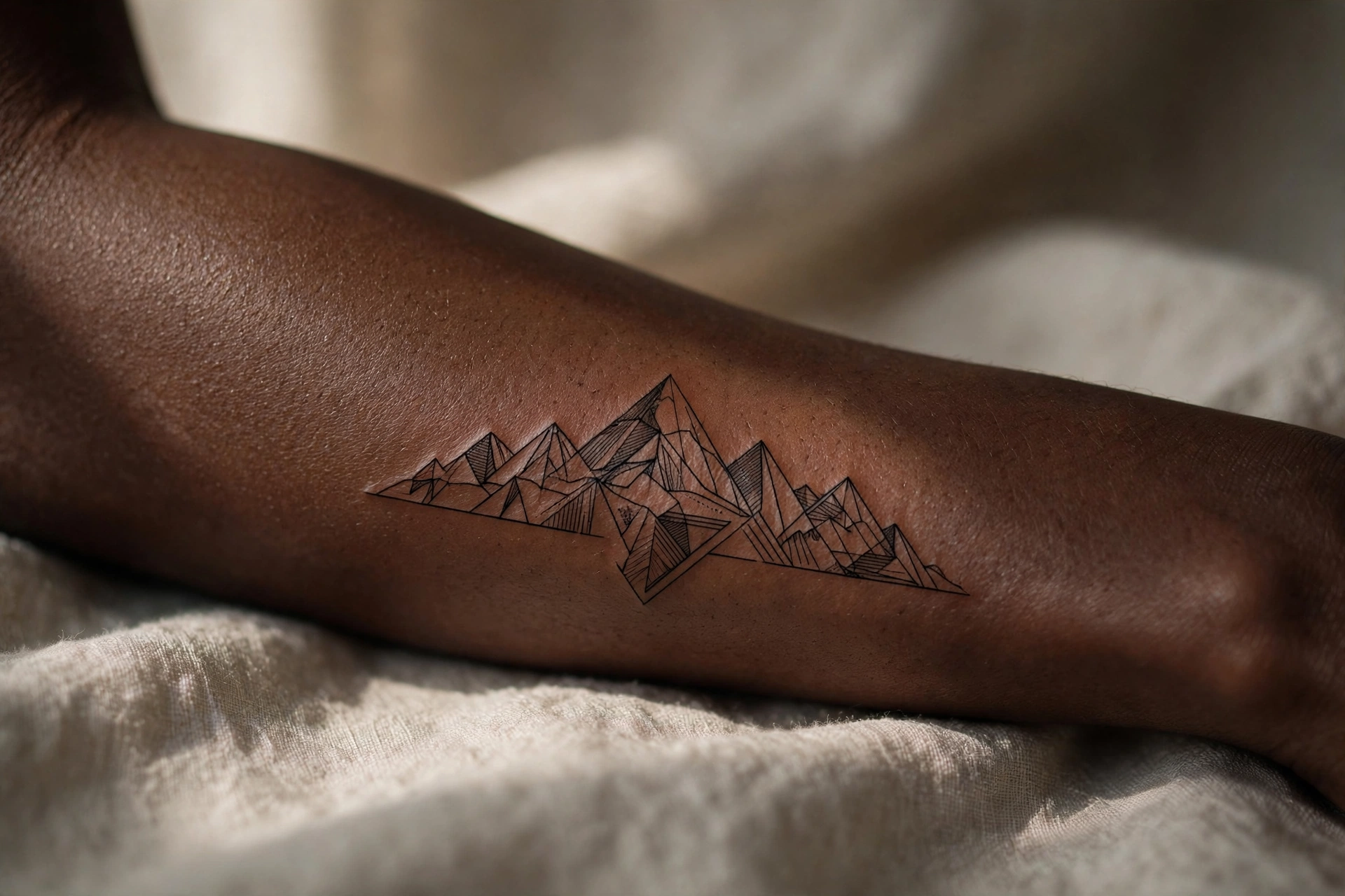 Mountain range silhouette tattoo on a man's bicep