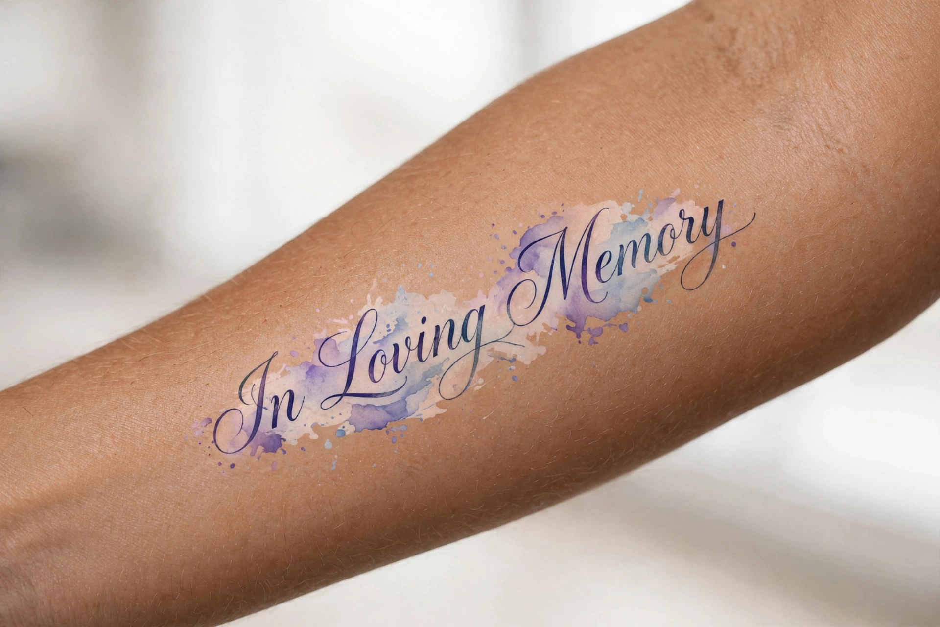 Elegant script memorial tattoo reading in loving memory on the forearm