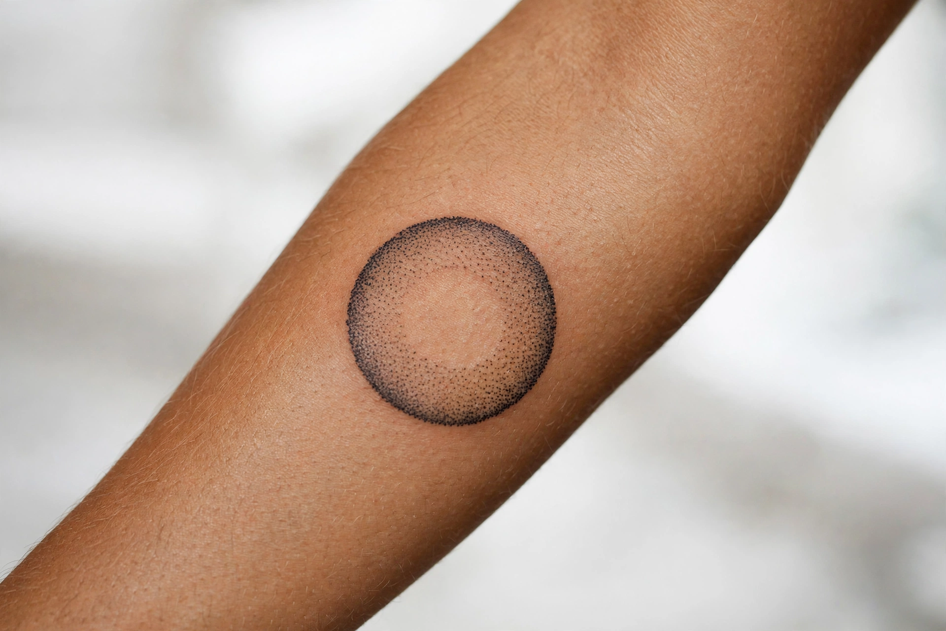 Dotwork gradient circle minimalist tattoo on man's chest