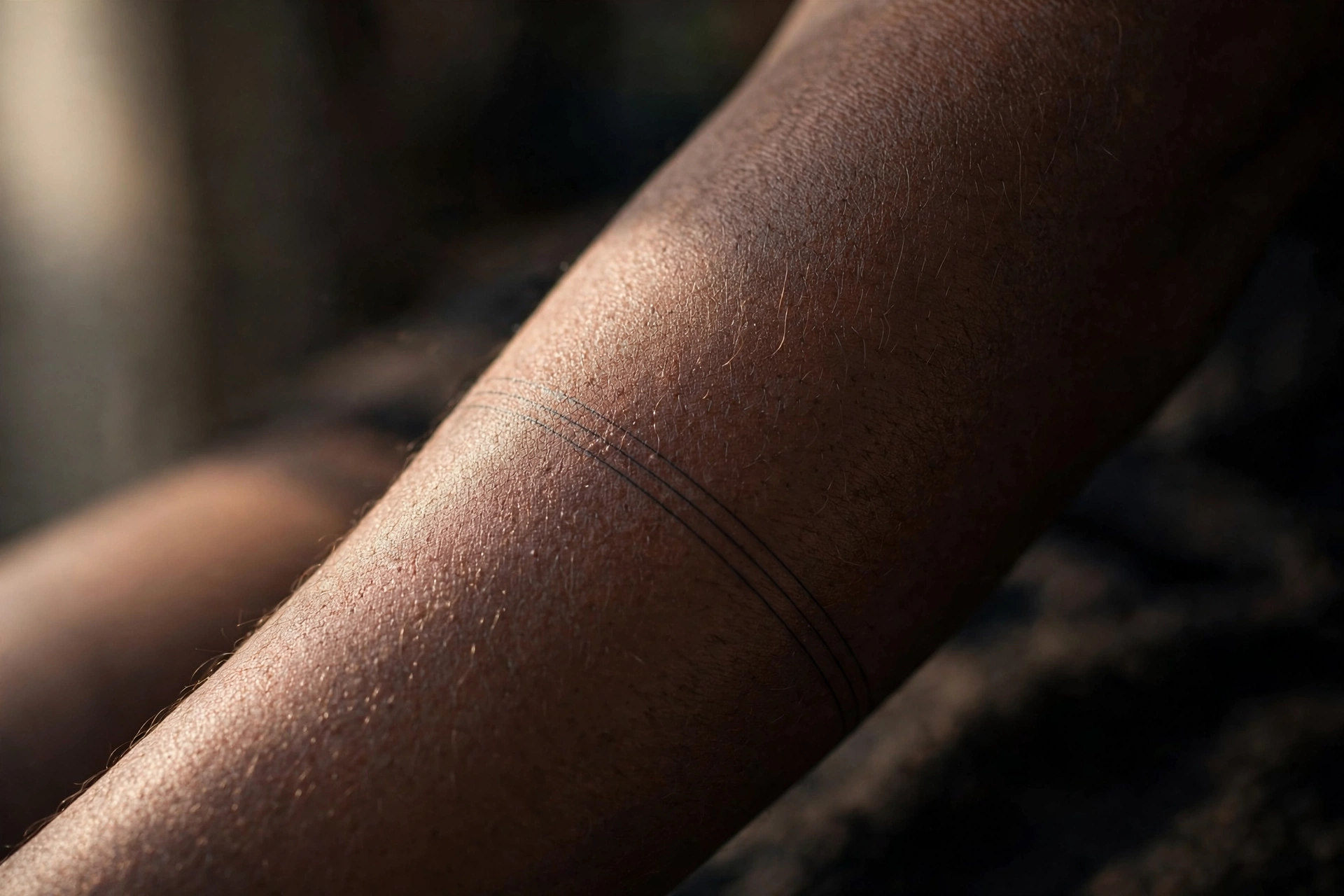 Tiny parallel lines band minimalist tattoo on man's wrist