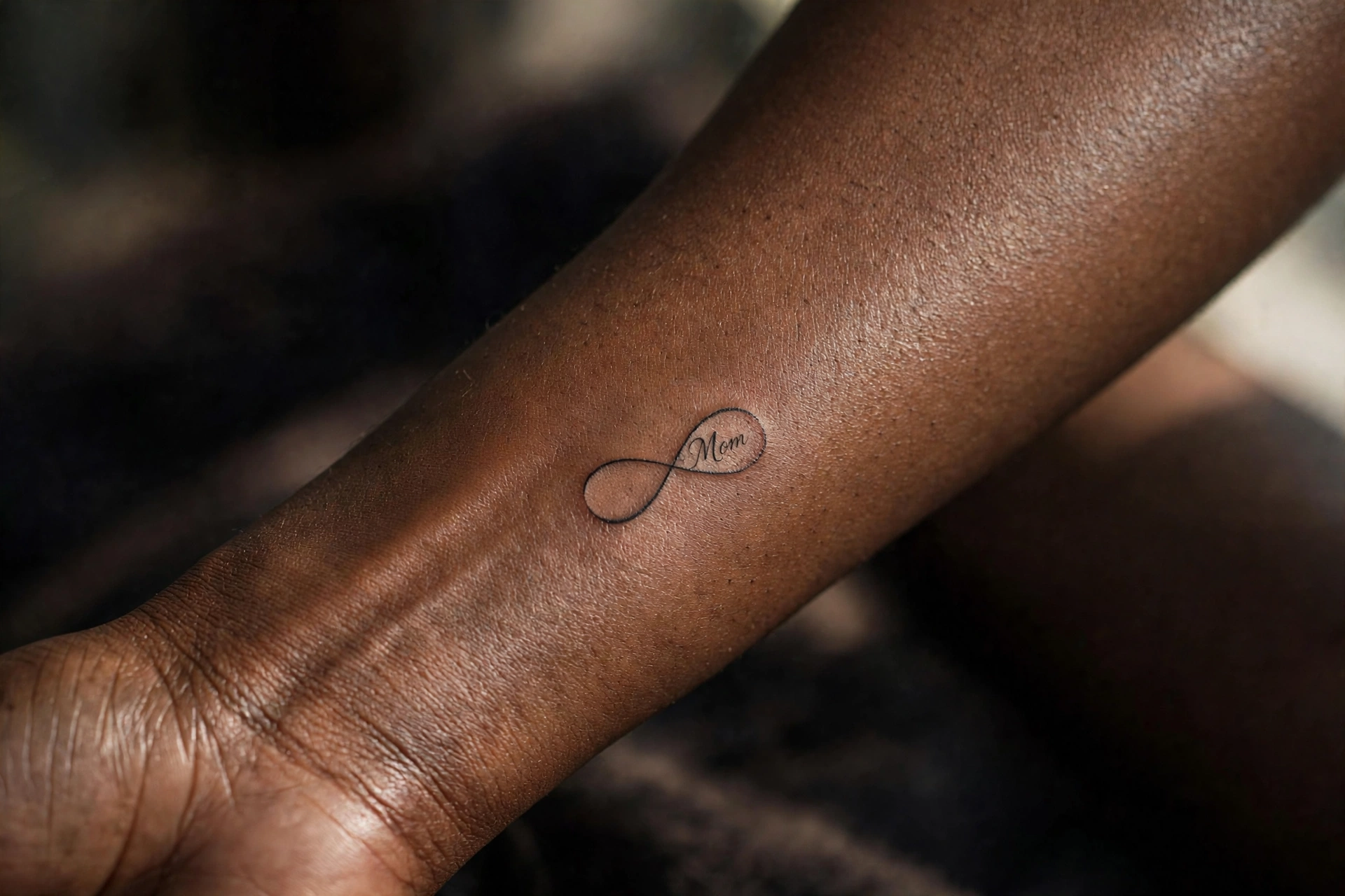 Infinity symbol tattoo with mom script inside