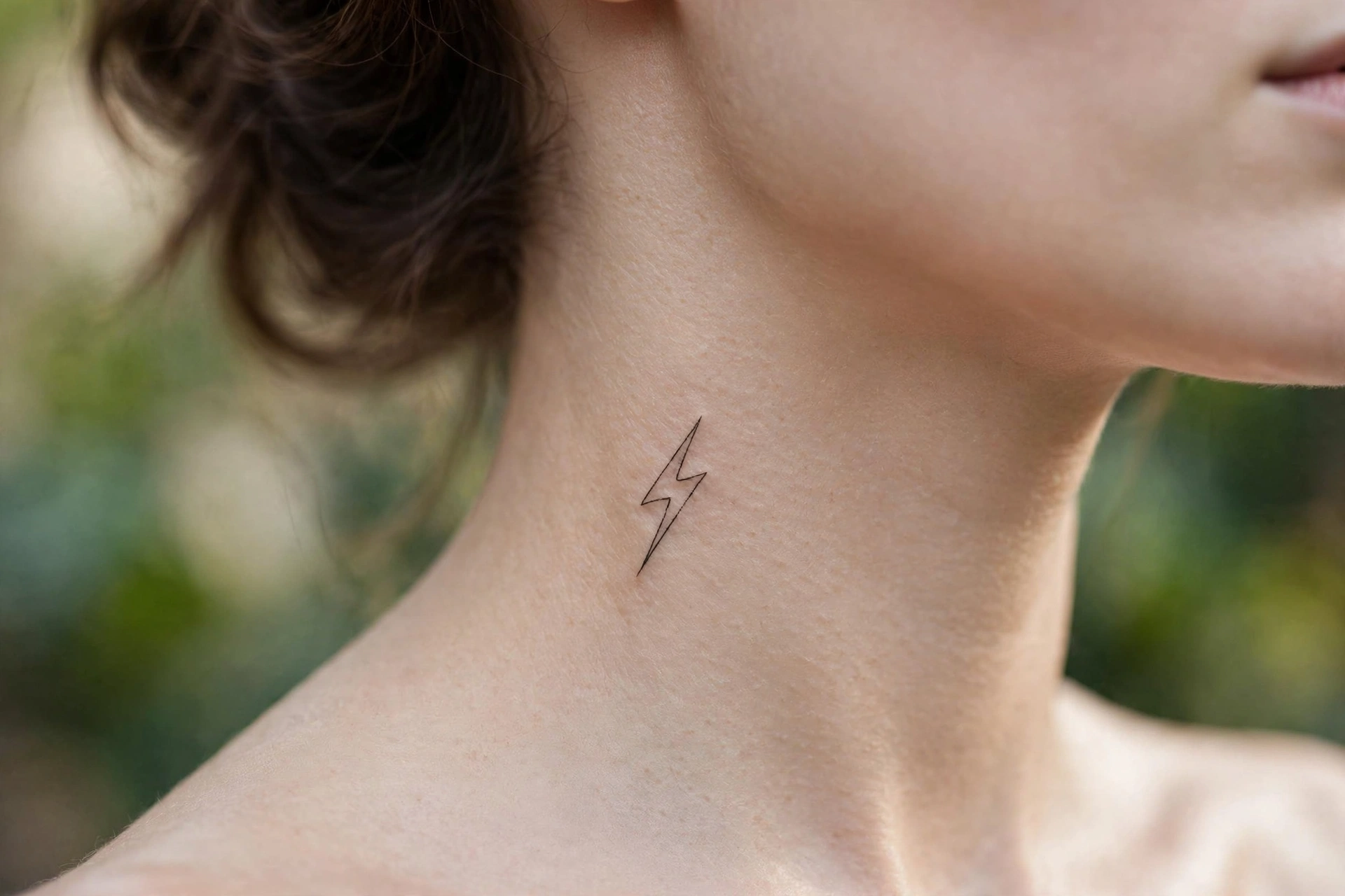 Symmetrical butterfly wings tattoo spread across a woman's throat