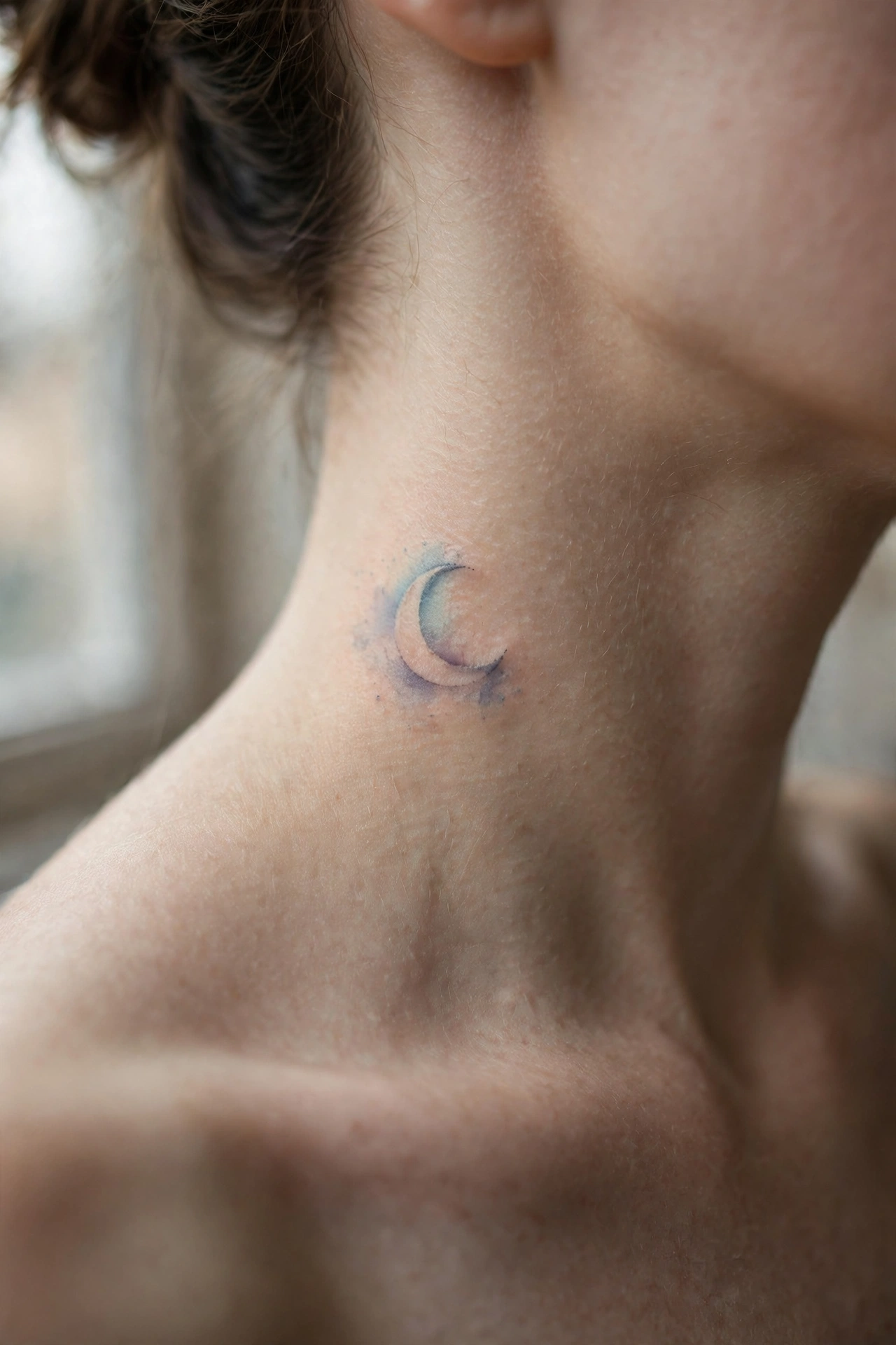 Tiny heart outline tattoo behind a woman's ear