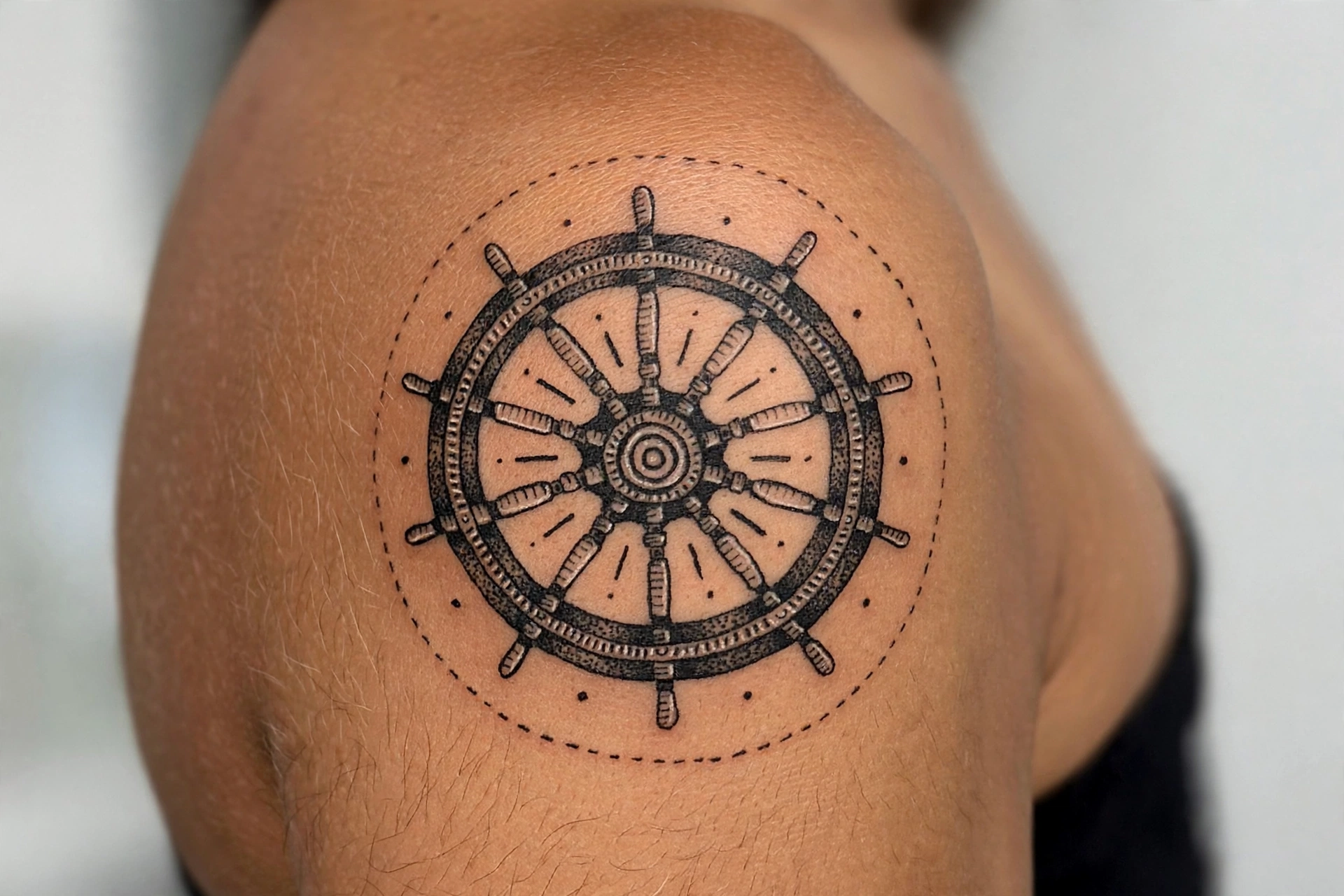Ship's helm wheel tattoo with ocean waves