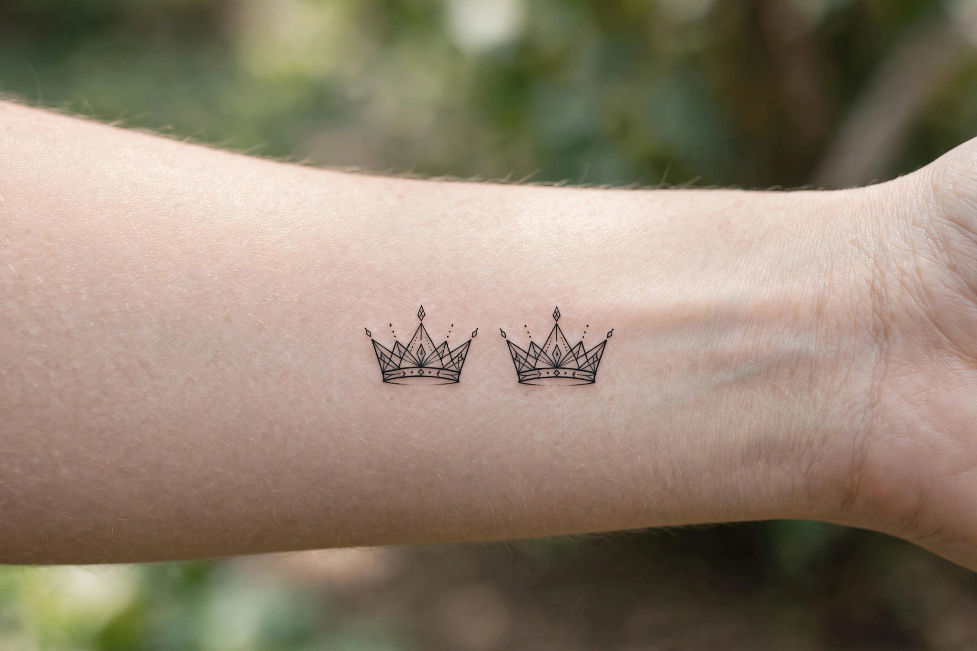 Matching small crown tattoos for siblings