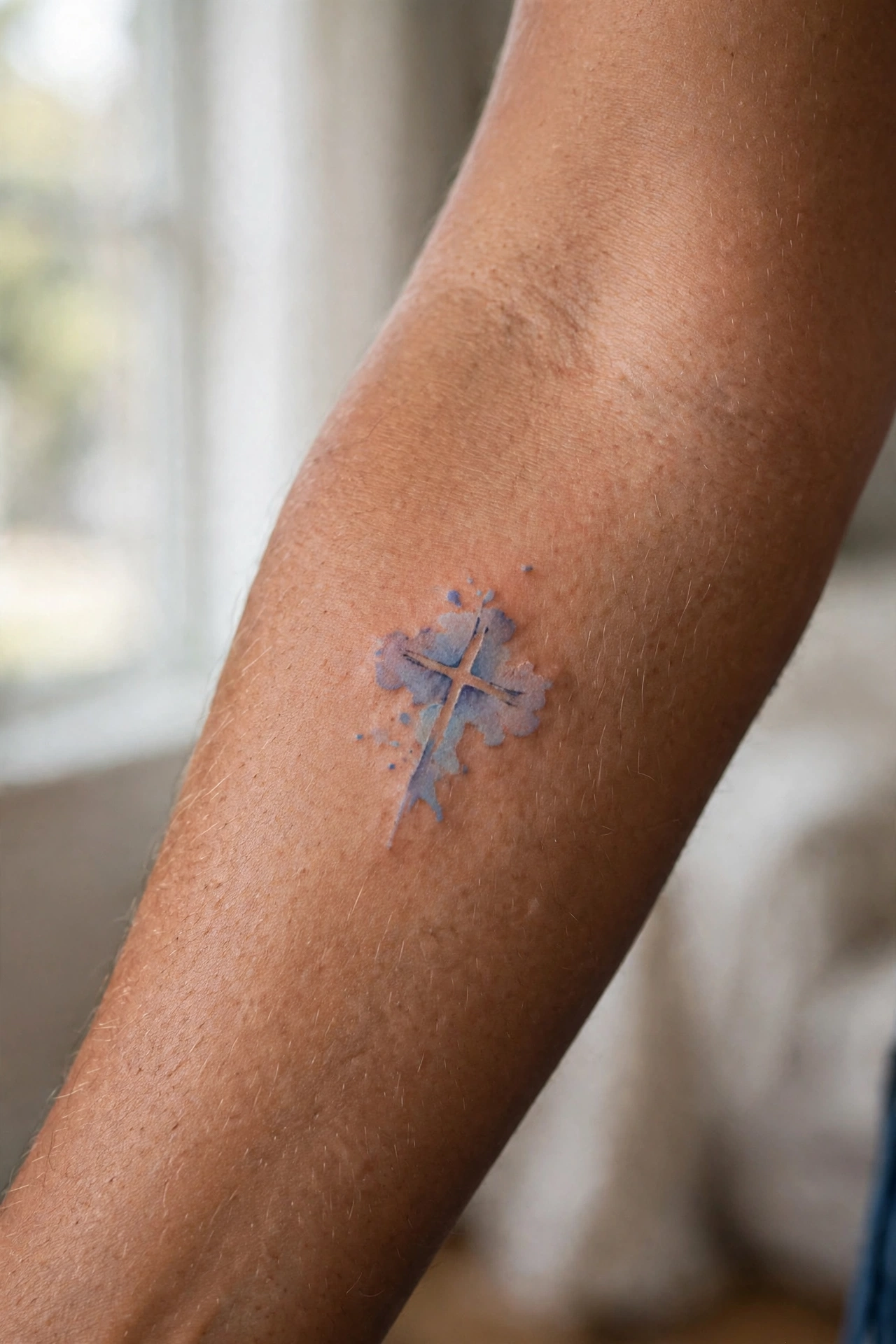 Small cross tattoo on man's finger