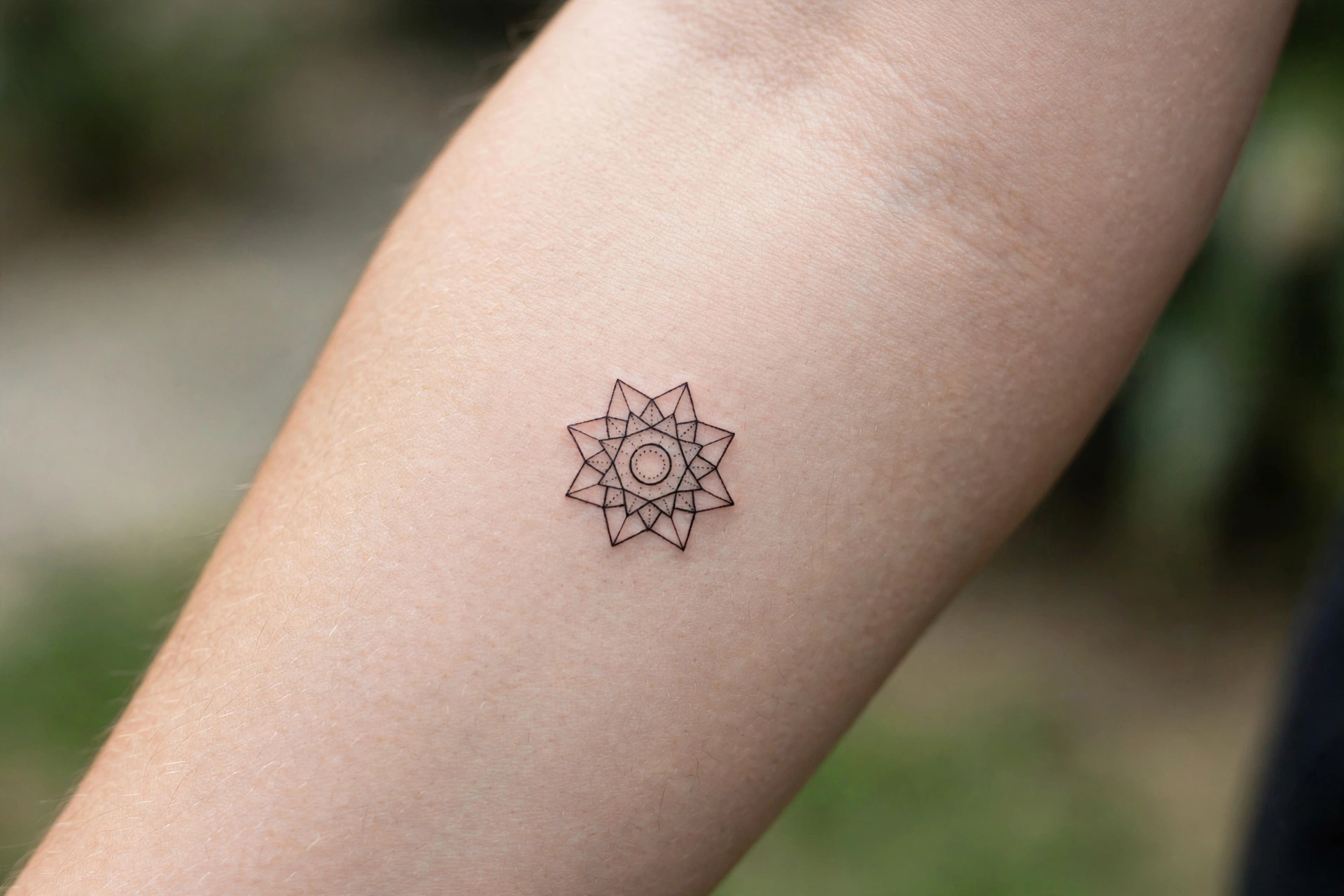 Small sun tattoo on man's shoulder