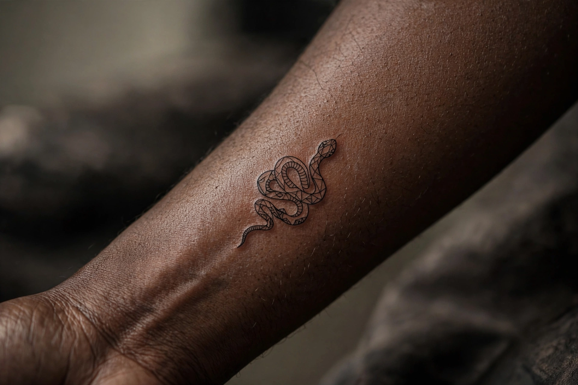 Small snake tattoo on man's finger
