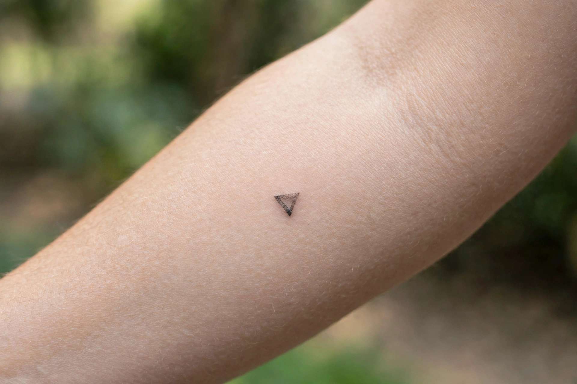 Tiny triangle tattoo behind man's ear