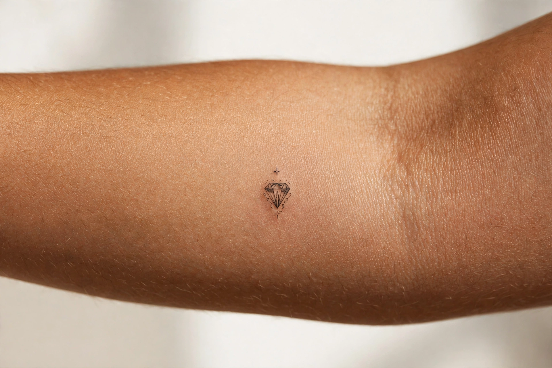 Small diamond tattoo on man's hand