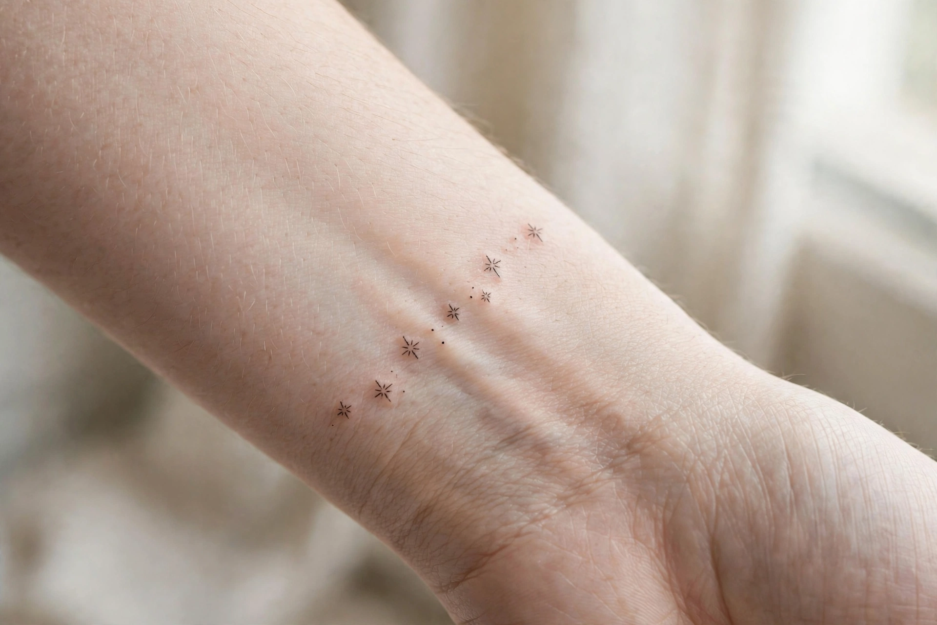 Leafy vine tattoo wrapping around a woman’s wrist